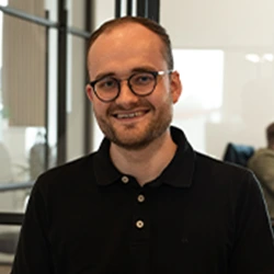 Projektmanager in einem schwarzen Hemd schaut in die Kamera