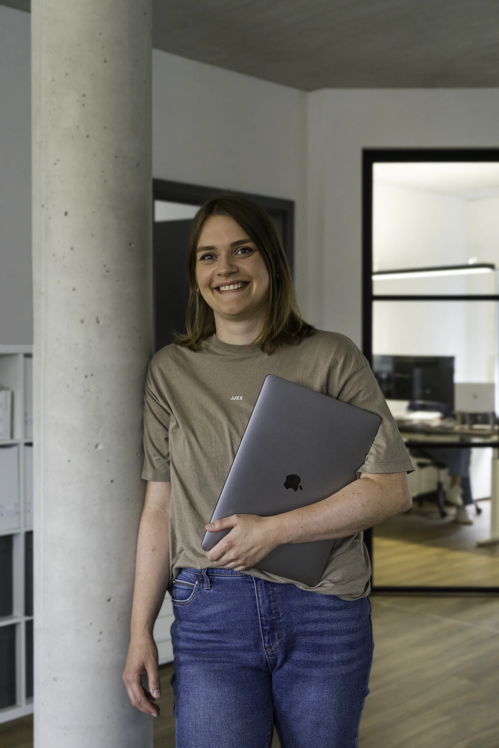 Mitarbeiterin der Moleco Werbeagentur in Ochtrup mit Laptop in einem modernen Office